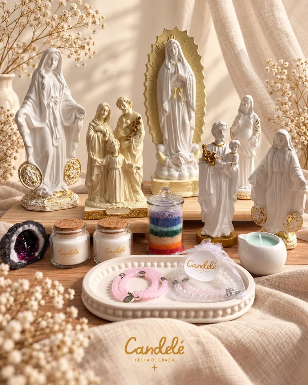 Figuras pintadas, velas y pulseras de Candelé sobre una mesa de madera